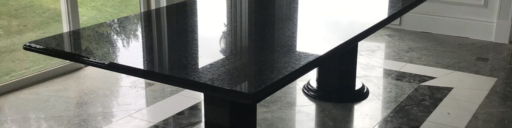 A black granite table on an inlaid stone floor