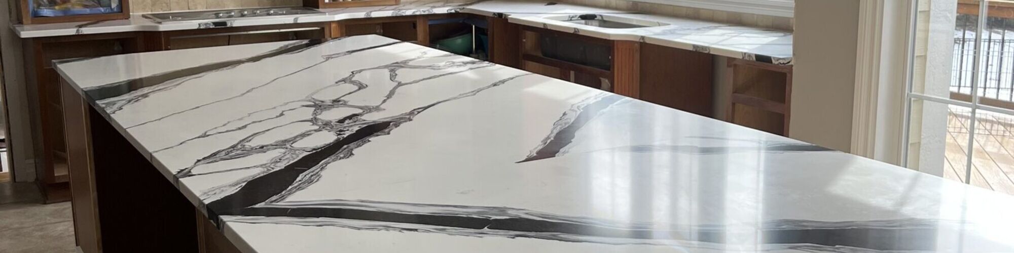 A dramatically veined stone countertop run in a kitchen