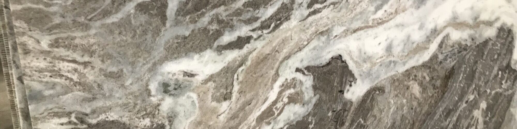 A marble slab with swirled grey and white veining