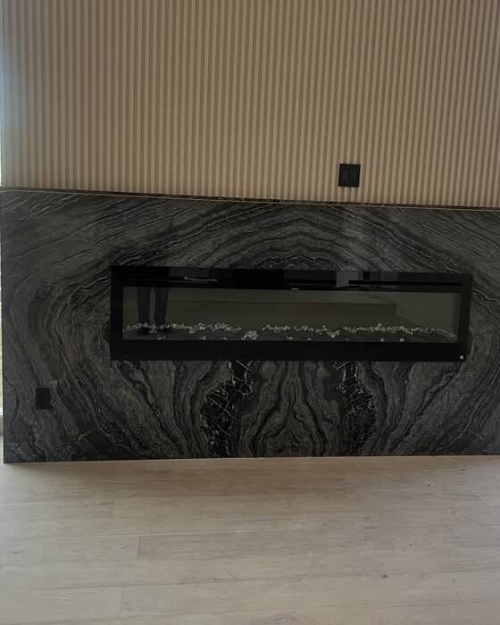 Stone fireplace surround fabricated by Beautiful Granite & Marble