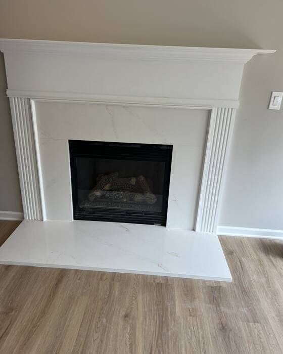 Stone fireplace surround fabricated by Beautiful Granite & Marble
